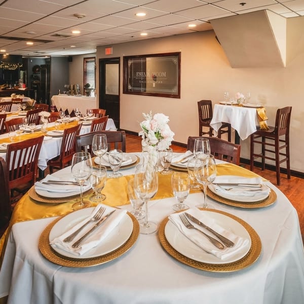 A restaurant dining room with tables set with white tablecloths, gold runners, and place settings.
